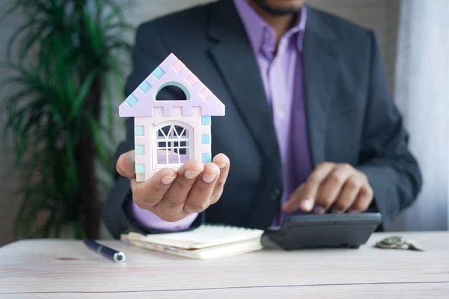 man holding model house